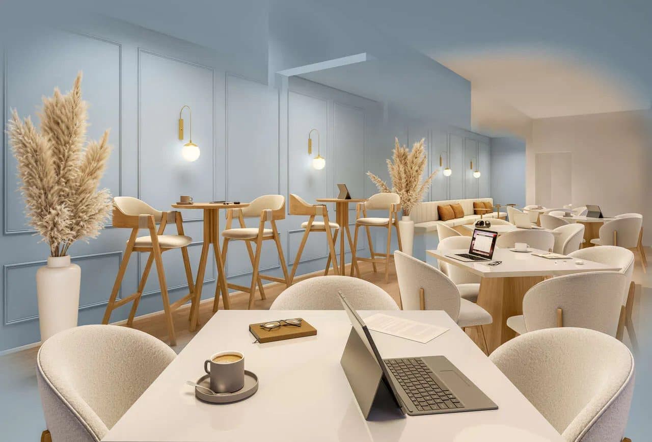 Ambiente interno decorado com mesas, cadeiras e parede em tom azul com painéis clássicos.