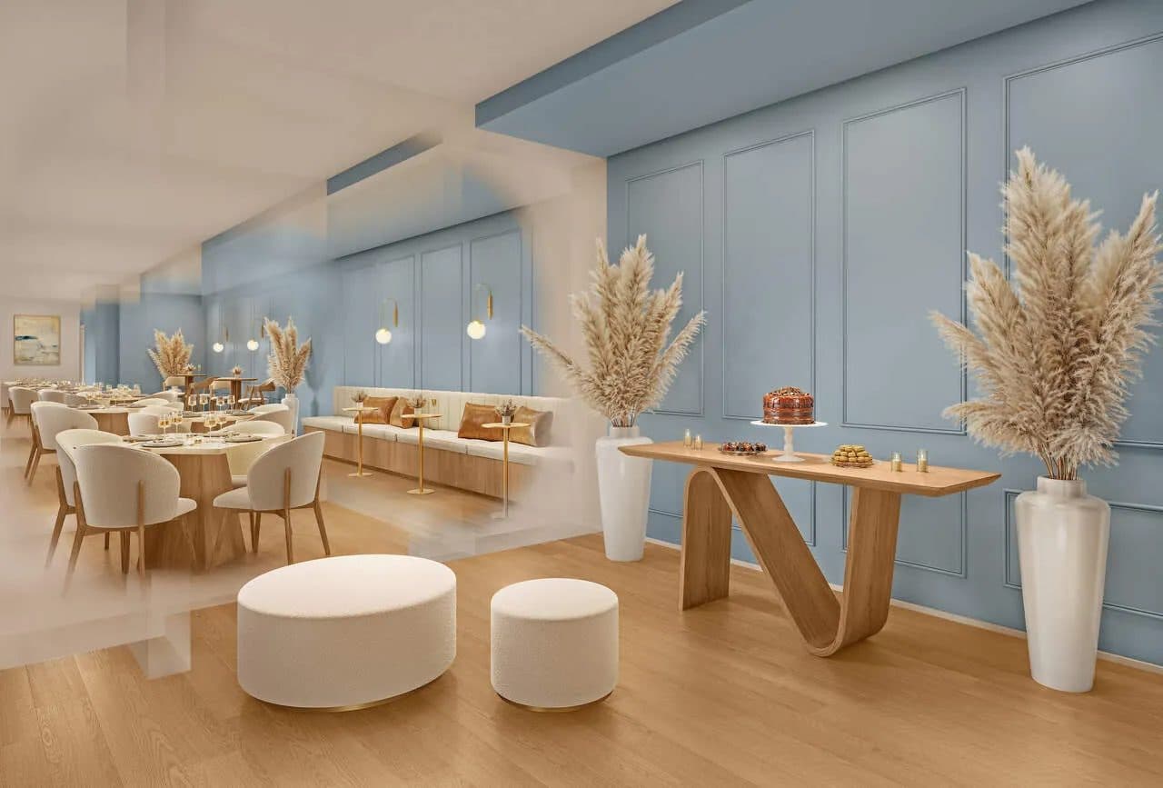 Salão de festas interno com mesas, cadeiras e parede com painéis decorativos.